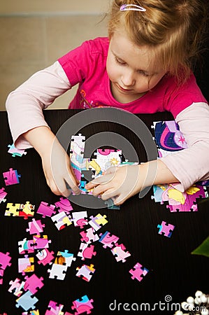 Girl playing with jigsaw puzzle Stock Photo