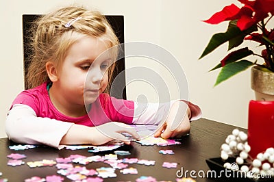 Girl playing with jigsaw puzzle Stock Photo