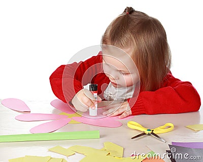 Girl playing with paper and glue Stock Photo