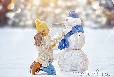 Girl playing with a snowman Stock Photo