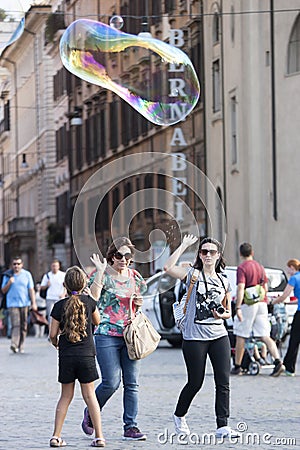 Girl plays with big soap bubble Editorial Stock Photo