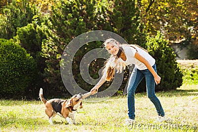 Girl plays with a dog in the yard Stock Photo