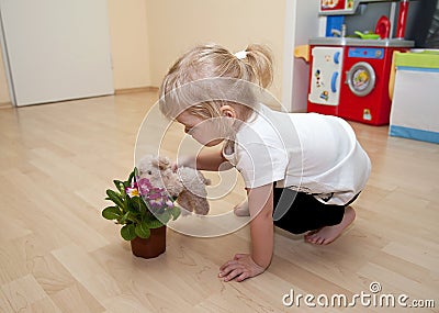Girl plays with flower and toy dog Stock Photo
