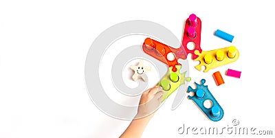 Child plays a game with colored wooden blocks. Sorter. The development of size, color. Stock Photo