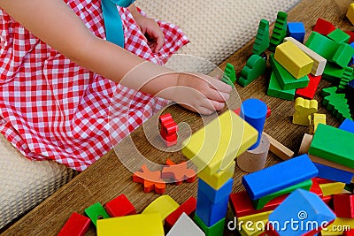 girl plays role-playing games with wooden figurines, figures, blocks, kindergarten games, concept of childhood, earlier child Stock Photo