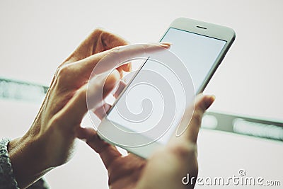 Girl pointing finger on screen smartphone.Female hands texting message mobile phone.Closeup on blurred light coloured Stock Photo