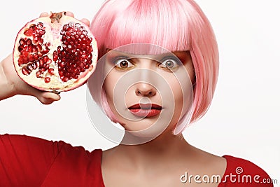 Girl with pomegranate. Pink hair. Makeup Stock Photo