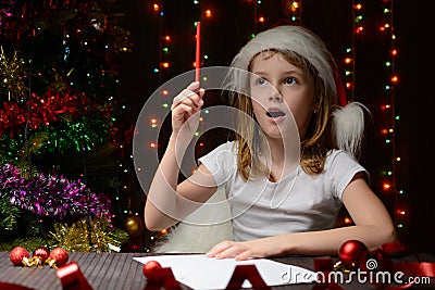 Girl pondered letter to Santa Claus Stock Photo