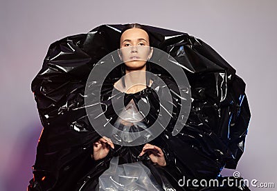 Girl posing in a dress made of plastic film. Fashion portrait. Stock Photo