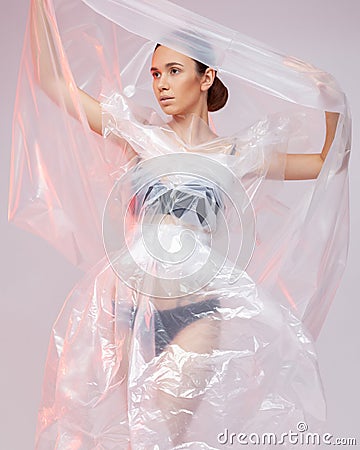 Girl posing in a dress made of plastic film. Fashion portrait. Stock Photo