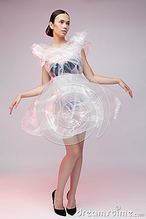 Girl posing in a dress made of plastic film. Fashion portrait. Stock Photo