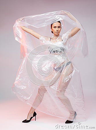 Girl posing in a dress made of plastic film. Fashion portrait. Stock Photo