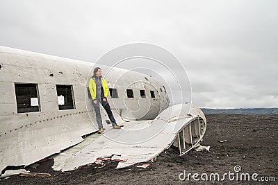 Girl posing near remainings of crashed airplane Stock Photo