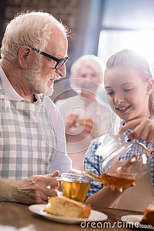 Girl pouring tea in cup Stock Photo