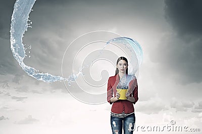 Girl pouring water from bucket . Mixed media Stock Photo