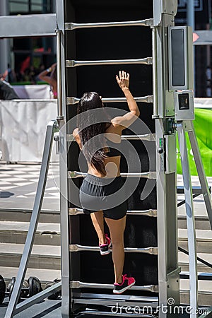 Girl Practicing Fitness Climbing a New Machine: Mobile Escalator for Sport Editorial Stock Photo