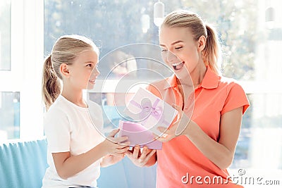 The girl prepared a surprise for her mother. Little girl prepared a gift for mom. Stock Photo