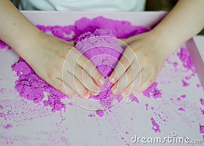 Girl preschooler sculpts kinesthetic sand Stock Photo