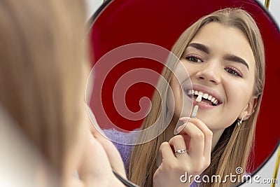 Girl on the procedure of teeth whitening checks the color tone of the teeth Stock Photo