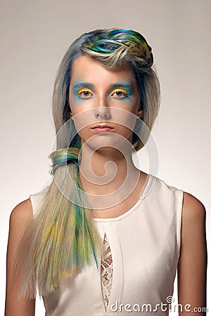 Girl with professional hair colouring and creative make up in peacock style Stock Photo