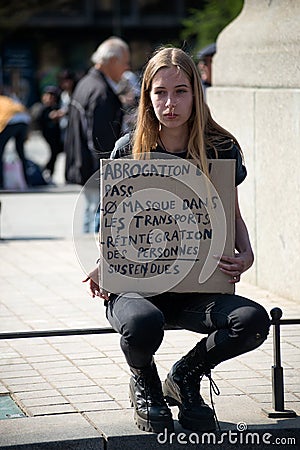 Girl protesting againstthe sanitary pass with text in frech : abrogation du pass vaccinal, en english : cancellation of the vacci Editorial Stock Photo