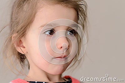 Girl with puffy cheeks, brown eyes and long eyelids pensively lo Stock Photo