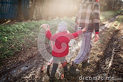 A girl pushes a bicycle with her older brother. Children of immigrants Stock Photo