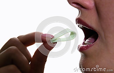 The girl puts chewing gum in her mouth. Stock Photo