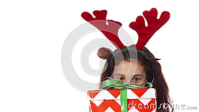 A sweet girl hides behind a Christmas gift box Stock Photo