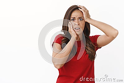 Girl reacts to person feeling pain, express emapthy and embarassment. Shocked speechless brunette female in red t-shirt Stock Photo