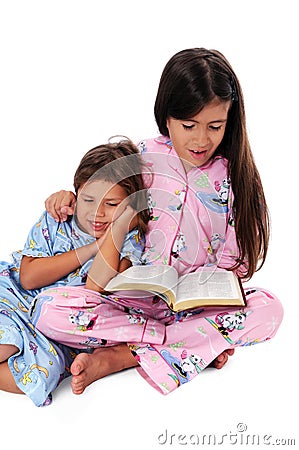 Girl Reading Bedtime Story to Sister Stock Photo