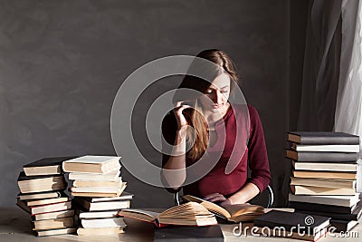 Girl reading a book in the library is preparing for the exam Stock Photo