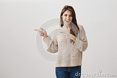 Girl is ready to except every proposal for drink. Portrait of charming caucasian brunette with excited smile pointing Stock Photo