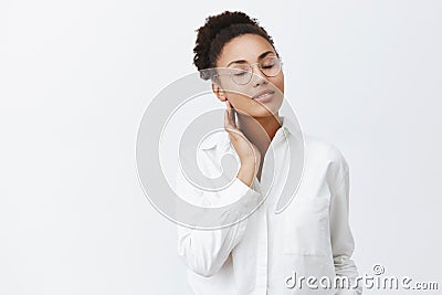 Girl recalls passionate kiss of lover. Portrait of tender feminine african-american woman in glasses and white shirt Stock Photo
