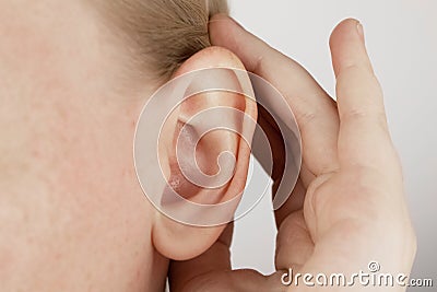 Darwin`s tubercle on the ear. The girl at the reception at the plastic surgeon, shows the auricle Stock Photo