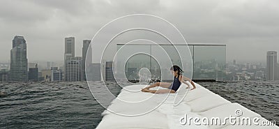 Girl on recliner beside pool Stock Photo