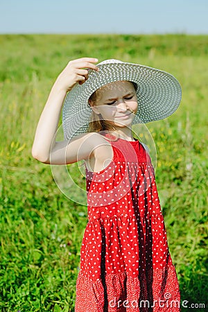 Girl in red dress and white hat with large brim Stock Photo