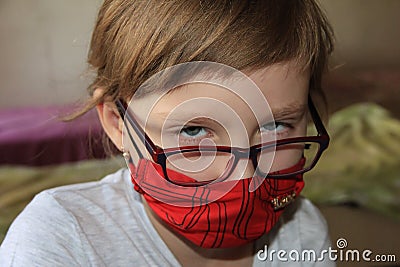 A girl in a red mask and glasses. A hurt child Stock Photo