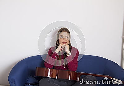 A girl in a red shirt sitting on a double chair. Stock Photo