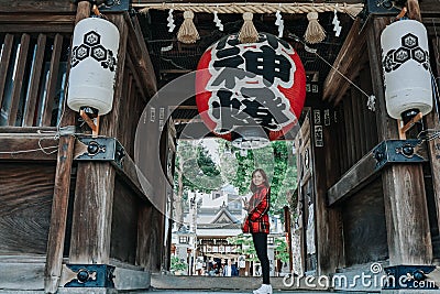 Girl in red suit in front of Kushida Shrine Editorial Stock Photo