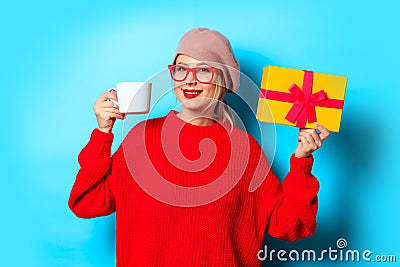 Girl in red sweater with gift box and cup of coffee Stock Photo