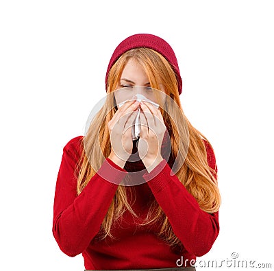 A girl in red sneezes and wipes her nose with her eyes ajar on a white isolated background Stock Photo