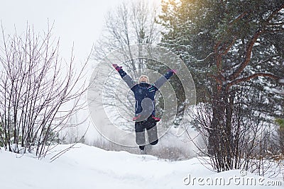 Girl rejoices in winter, a girl jumping in the winter forest. Stock Photo