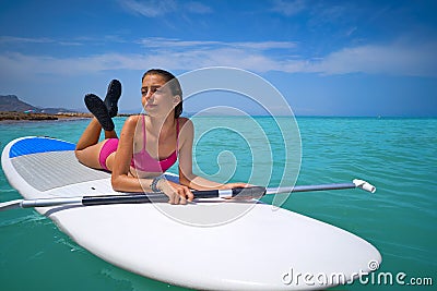 Girl relaxed lying on paddle surf board SUP Stock Photo