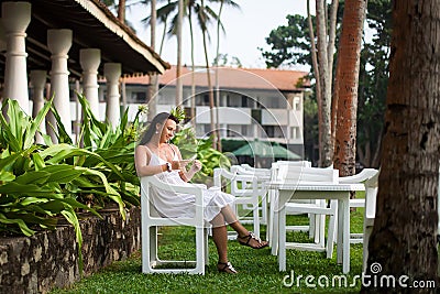 Girl resting on the lawn. bride on honeymoon. hotel territory. relaxation area. woman sitting on a green lawn Stock Photo