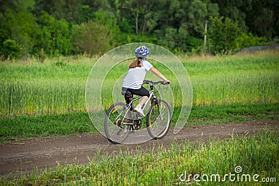 Girl ride on bike on rural landscape Stock Photo