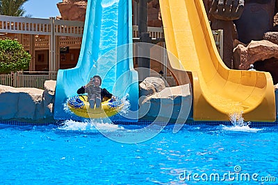 Girl ride on a water park slides with and use smartphone Editorial Stock Photo