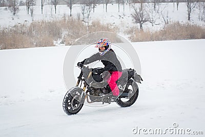 A girl rides a motorcycle on a frozen lake Editorial Stock Photo