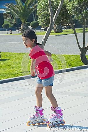 The girl rides on roller skates in the park Editorial Stock Photo