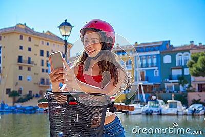 Girl riding a foldable e-bike in a Mediterranean marina Stock Photo